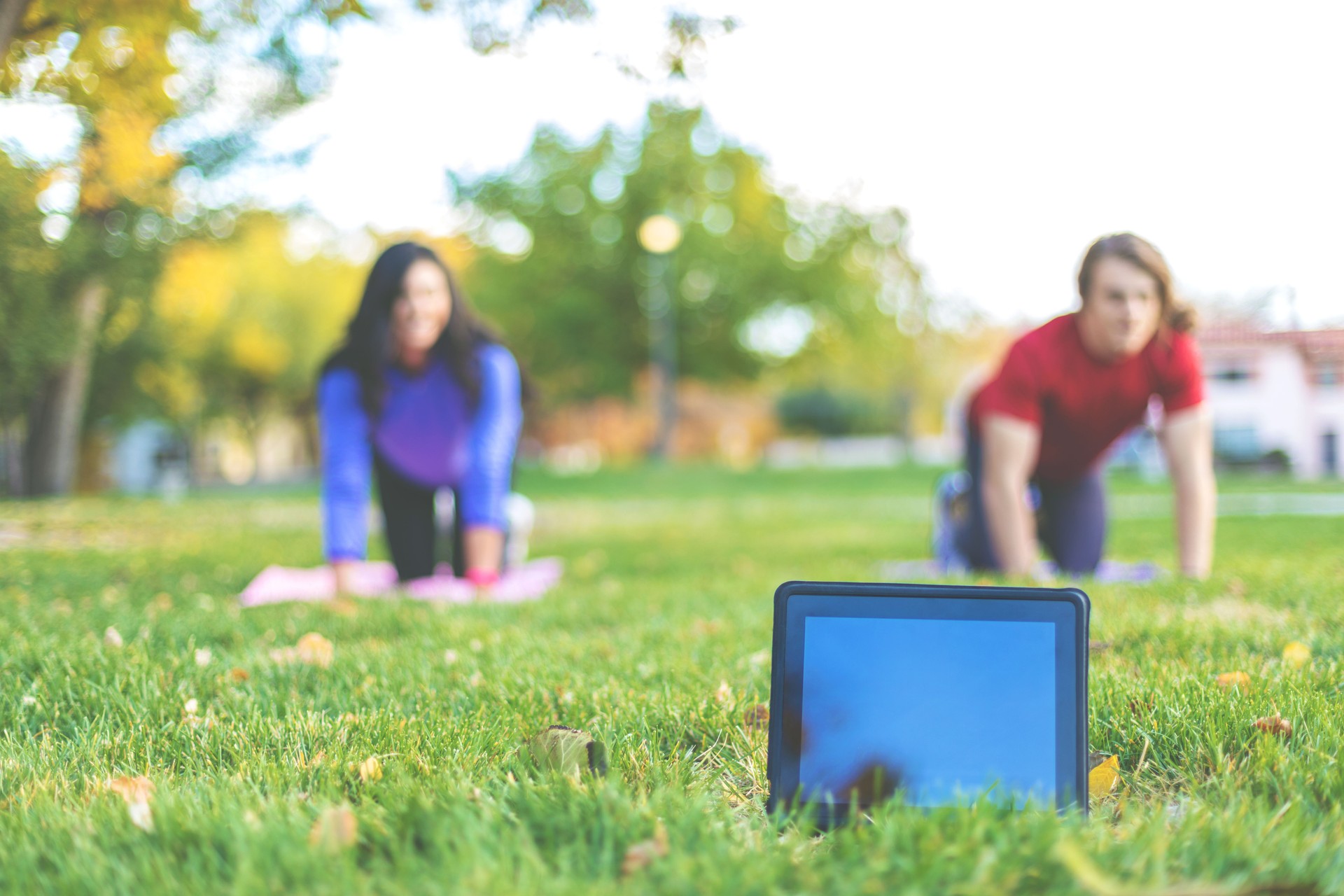 Millennial Young Adult Male and Female Outdoor Yoga Exercise in a Public Park with Technology